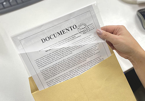 Close na mão de um técnico segurando um frasco durante análise química em laboratório industrial.