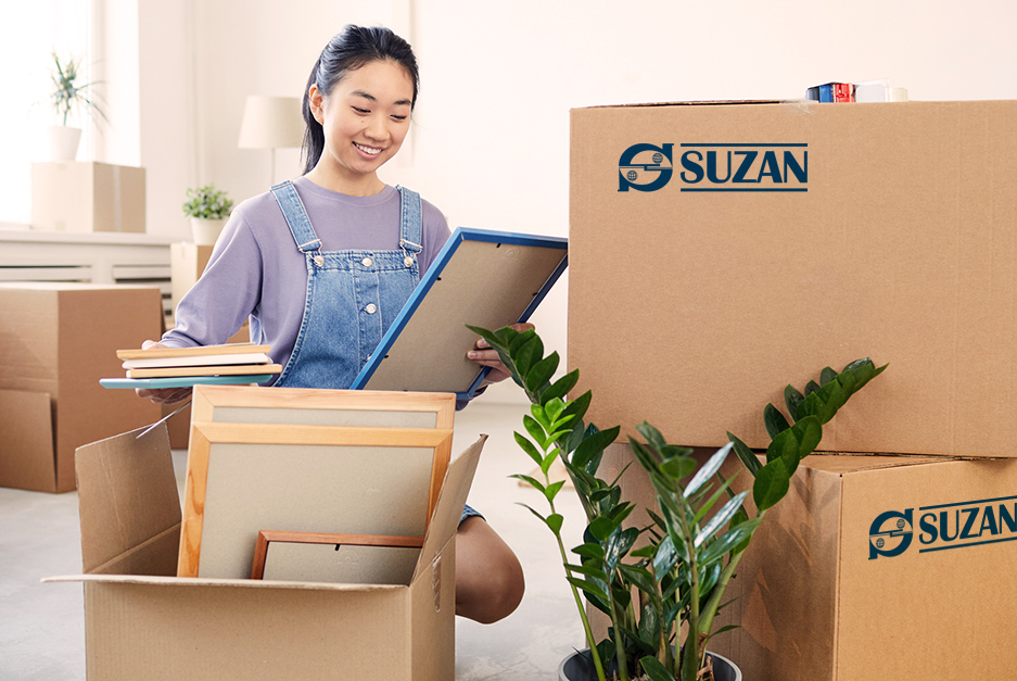 Mulher arrumando caixas para transporte.