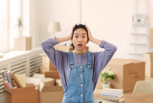 Mulher estressada arrumando caixas para transporte.